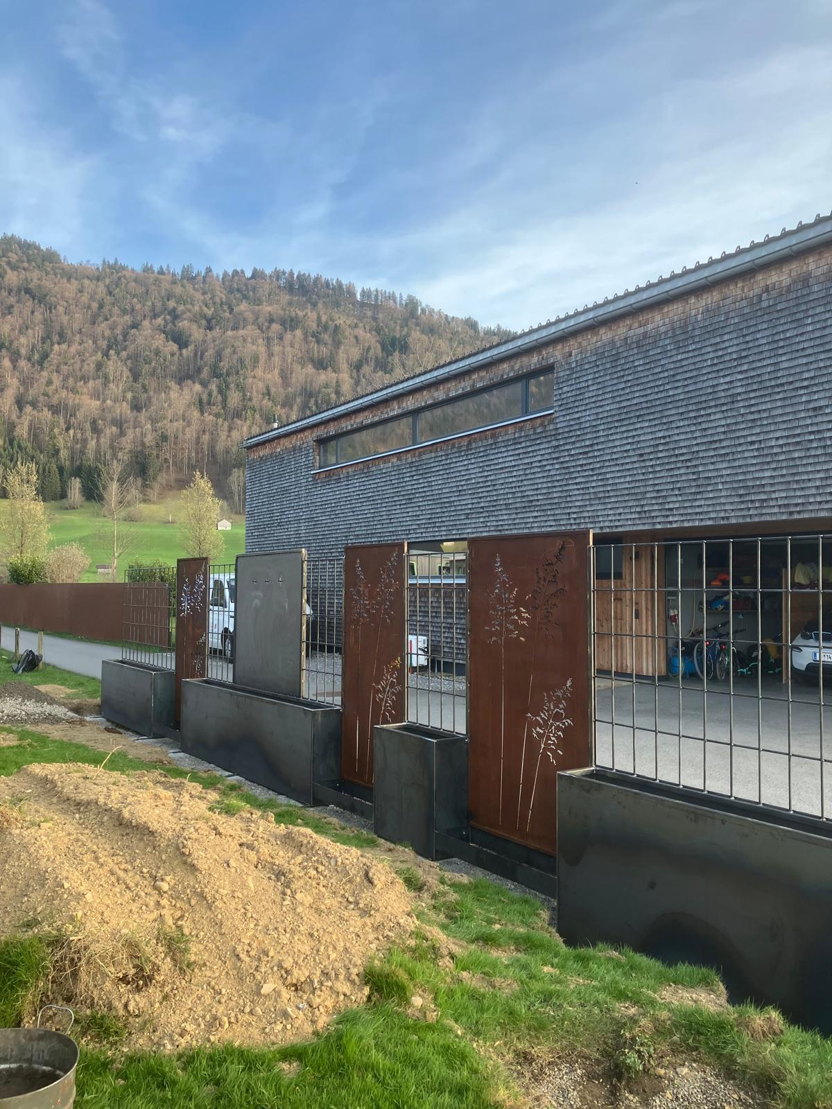 Ein Sichtschutz im Garten. Material ist Edelstahl & Cortenstahl. Es gibt kleine Hochbeete, Rankhilfen und gefräste Dekorationen.